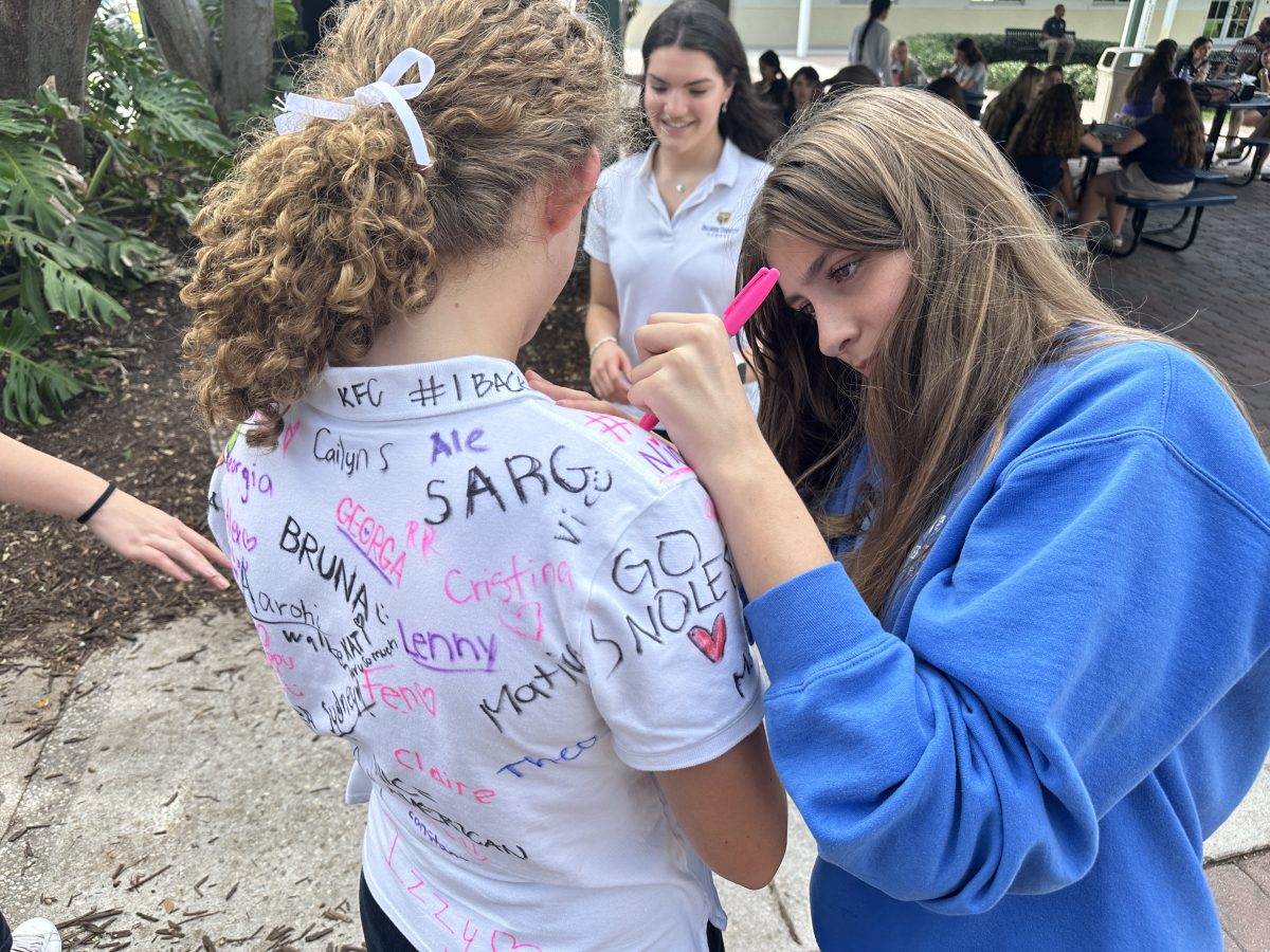 Nicole Oeltjen and other sophomores sign Australian exchange student Nicola Barnes shirt on Oct. 28 for her last day at Palmer Trinity. I loved Miami so much and have so many fun memories from this experience, Barnes said. I am going to miss Miami and everyone here so much.